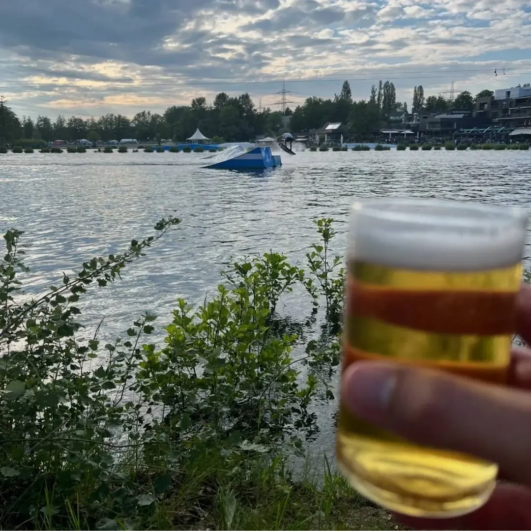 Feierabendbier am Ufer von Wasserski Langenfeld, im Hintergrund die Seilbahn in der Abendsonne